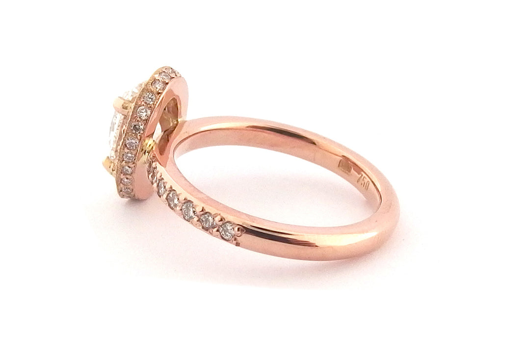 18ct rose gold halo ring, set with an oval diamond and bead set diamonds on the band