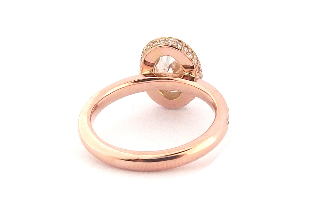 18ct rose gold halo ring, set with an oval diamond and bead set diamonds on the band