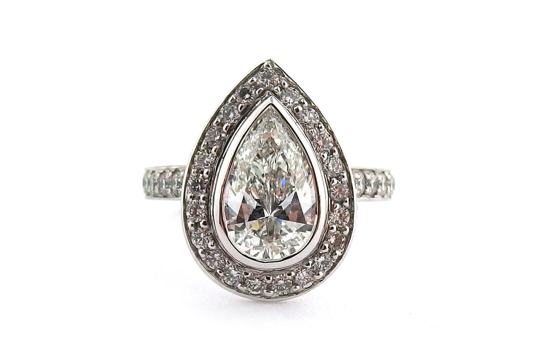 18ct white gold bezel set pear shape diamond halo ring with diamonds on the band