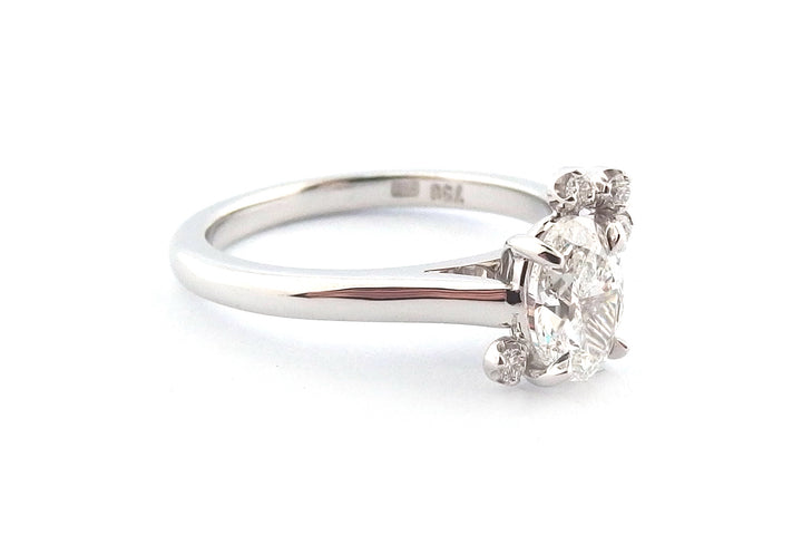 18ct white gold oval diamond with a small cluster of round diamonds