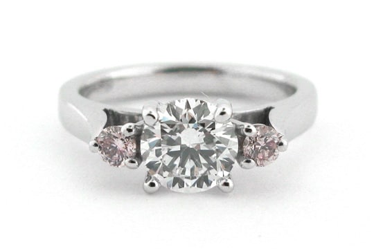 Round brilliant cut white and pink diamond three stone ring