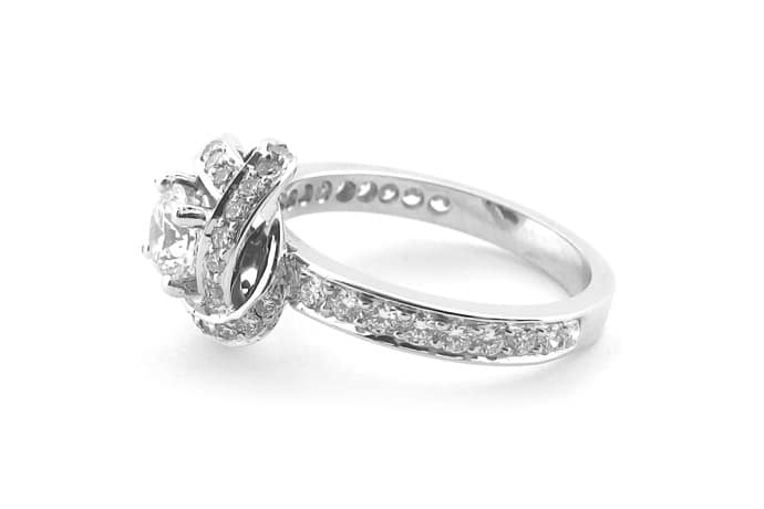 18ct white gold round brilliant cut ring with a knot shape halo