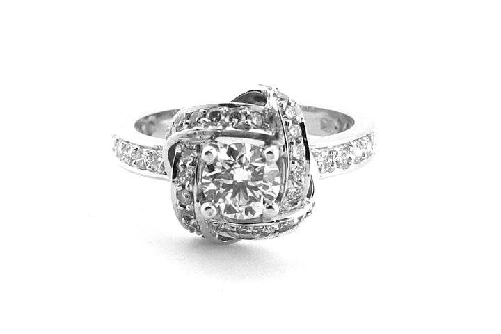 18ct white gold round brilliant cut ring with a knot shape halo