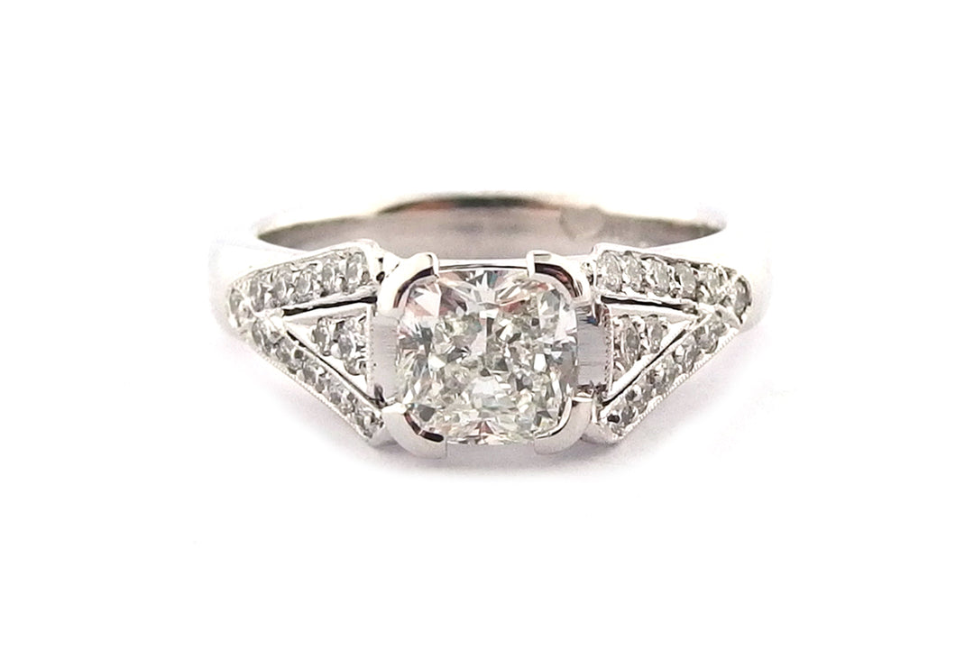 Cushion cut diamond with bead set diamonds and a milgrain edge