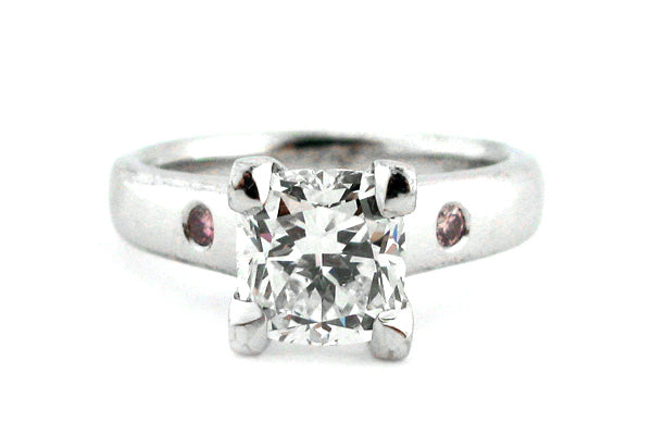 Cushion cut ring with two hammer set pink diamonds