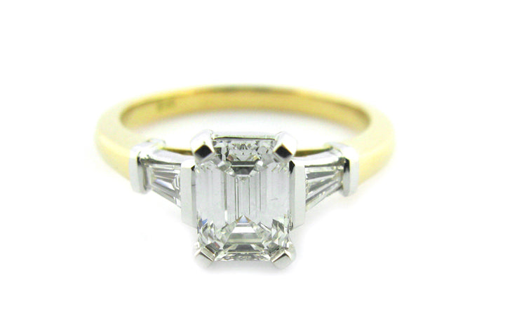 Emerald and tapered baguette diamond three stone ring