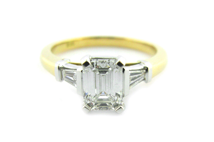 Emerald and tapered baguette diamond three stone ring