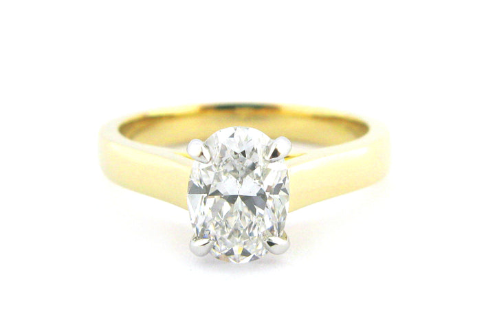 Two tone gold ring with four claw set oval diamond