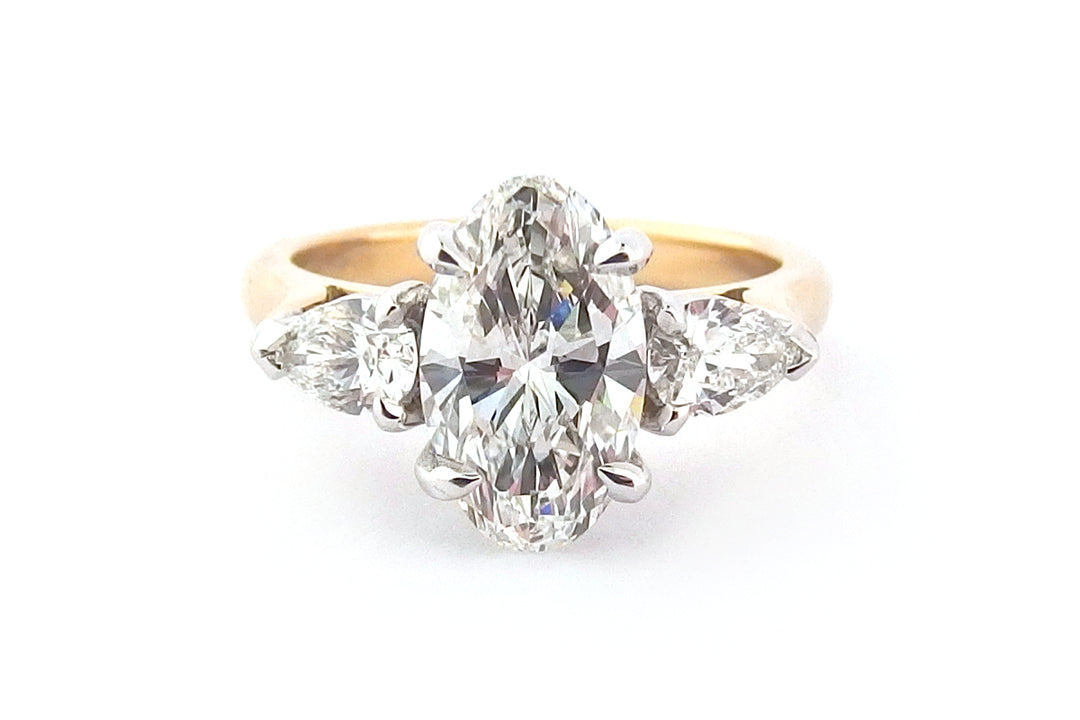 Oval diamond ring with pear shape side stones
