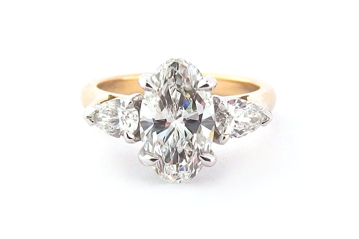 Oval diamond ring with pear shape side stones