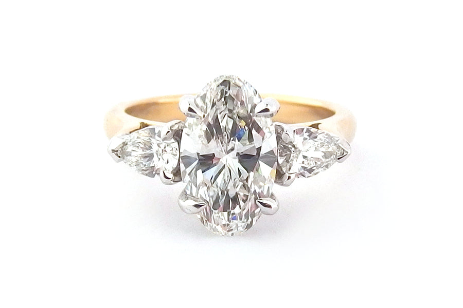 Oval diamond ring with pear shape side stones