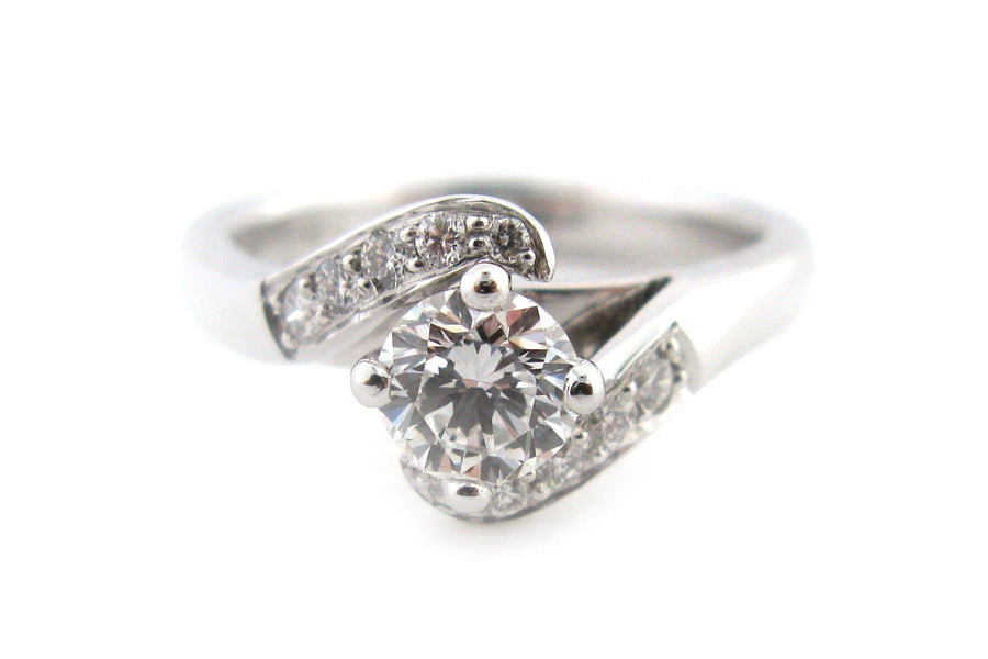 Round brilliant cut diamond ring with bead set diamonds on the twisted band