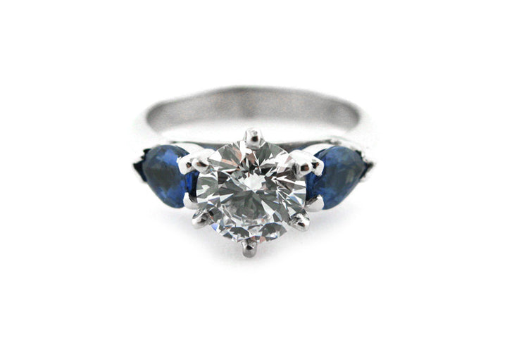 Six claw set round brilliant cut diamond with pear shape sapphire sides