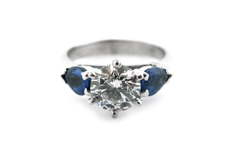 Six claw set round brilliant cut diamond with pear shape sapphire sides