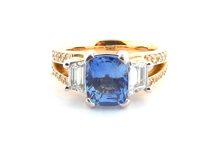 Three stone ring with a cushion cut sapphire and a split band