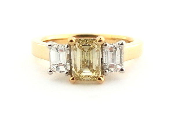 Yellow emerald cut diamond ring with two white emerald cut side diamonds