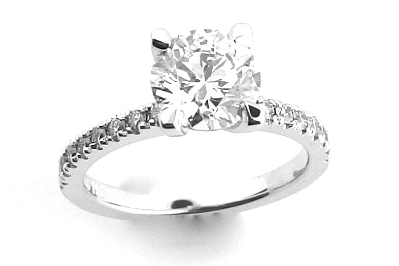 Four claw round brilliant cut ring with claw set diamond band