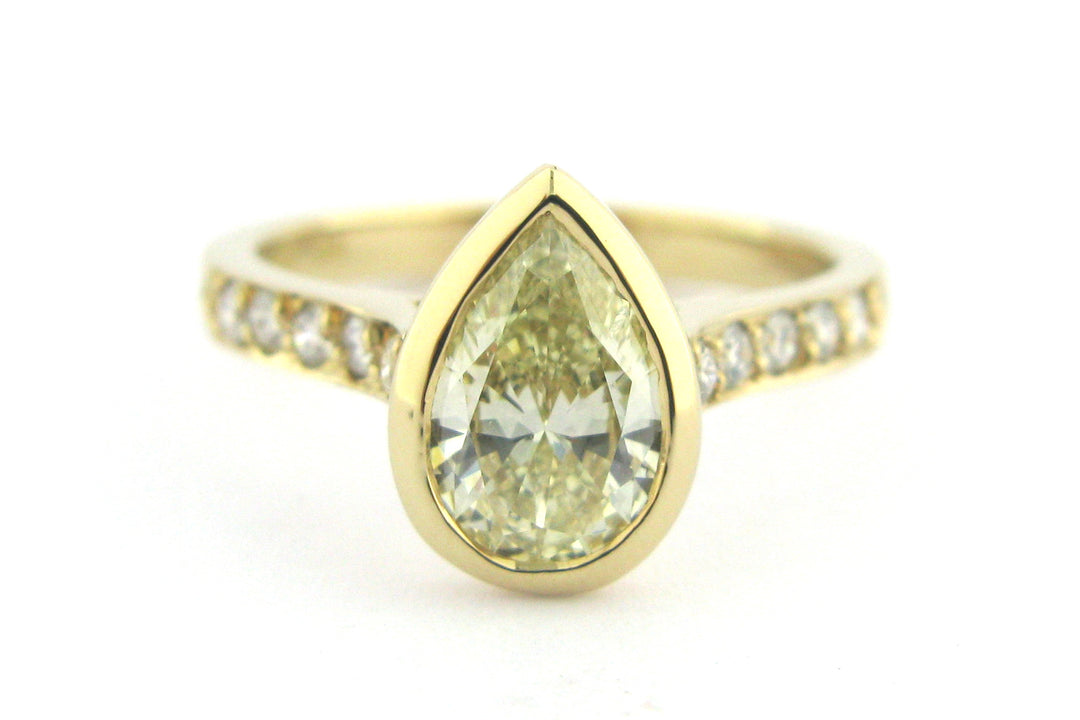 Bezel set pear shape diamond ring with bead set diamonds