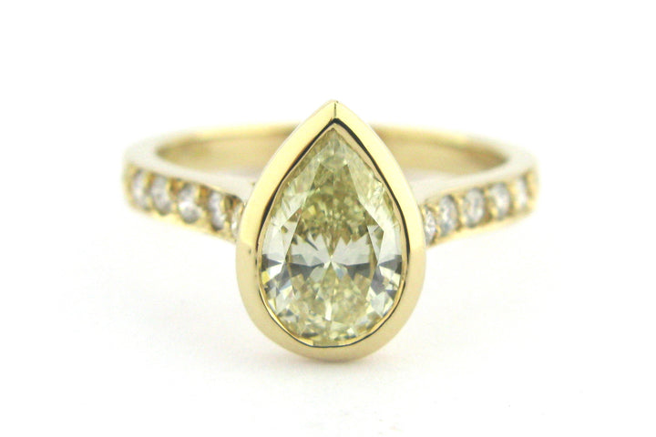 Bezel set pear shape diamond ring with bead set diamonds