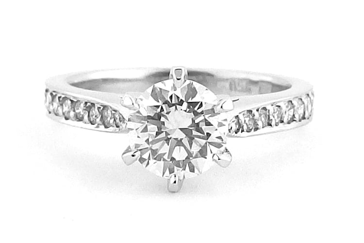 Six claw set round brilliant cut ring with bead set diamonds