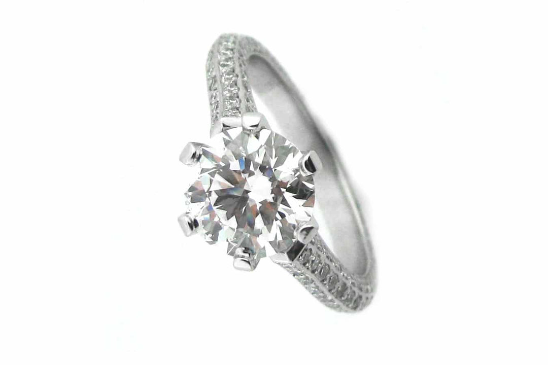 Claw set round brilliant cut ring with knife edge band