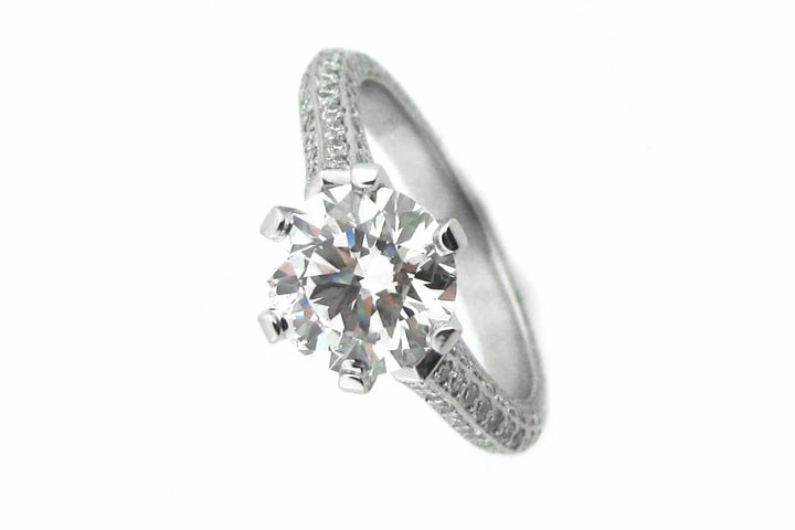 Claw set round brilliant cut ring with knife edge band