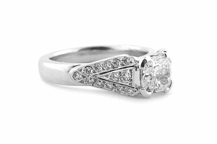 Cushion cut diamond with bead set diamonds and a milgrain edge