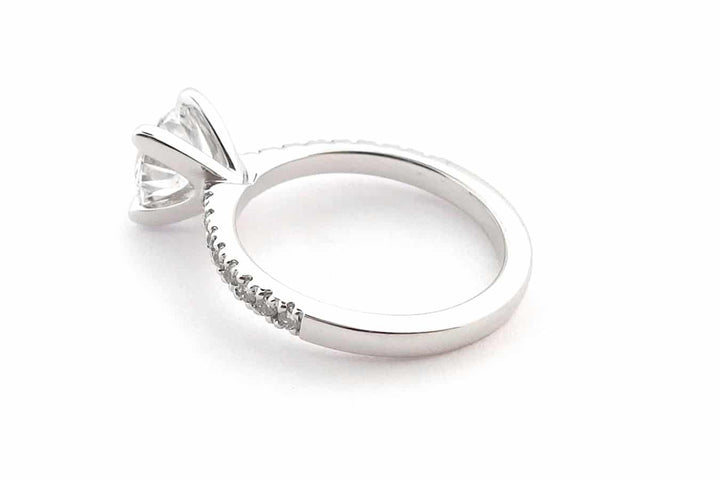 Four claw round brilliant cut ring with claw set diamond band