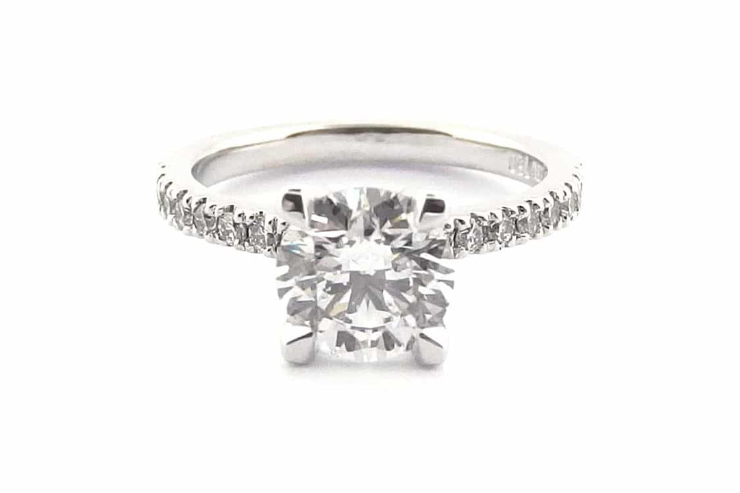 Four claw round brilliant cut ring with claw set diamond band