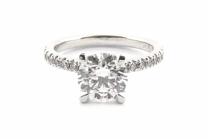 Four claw round brilliant cut ring with claw set diamond band