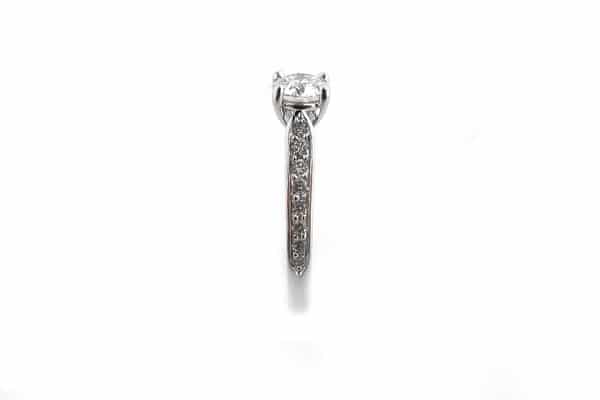 Four claw set round brilliant cut diamond ring with graduated bead set diamonds