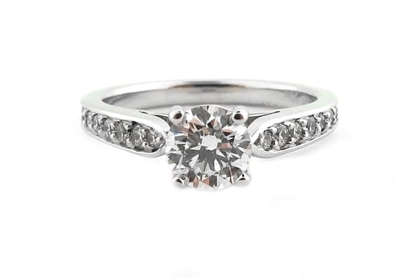 Four claw set round brilliant cut diamond ring with graduated bead set diamonds