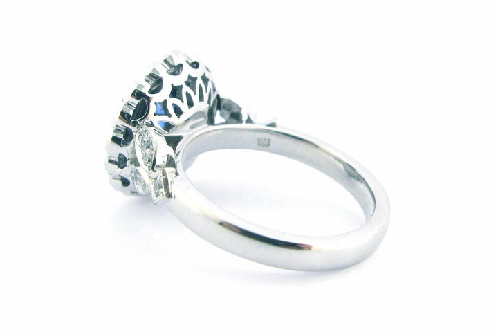 Cushion cut sapphire with a halo of bezel set diamonds