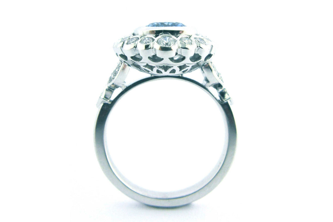 Cushion cut sapphire with a halo of bezel set diamonds