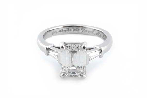 Platinum ring with a four claw set emerald cut diamond and tapered baguettes