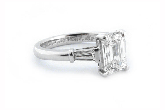 Platinum ring with a four claw set emerald cut diamond and tapered baguettes
