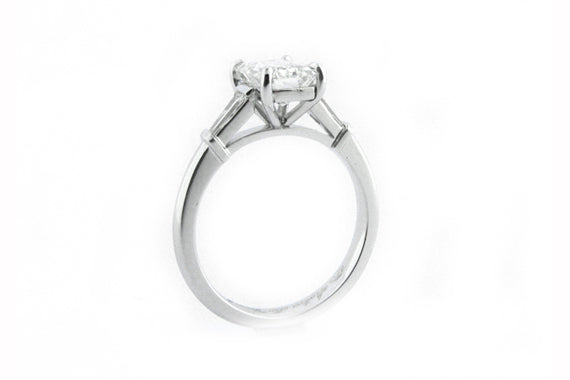 Platinum ring with a four claw set emerald cut diamond and tapered baguettes