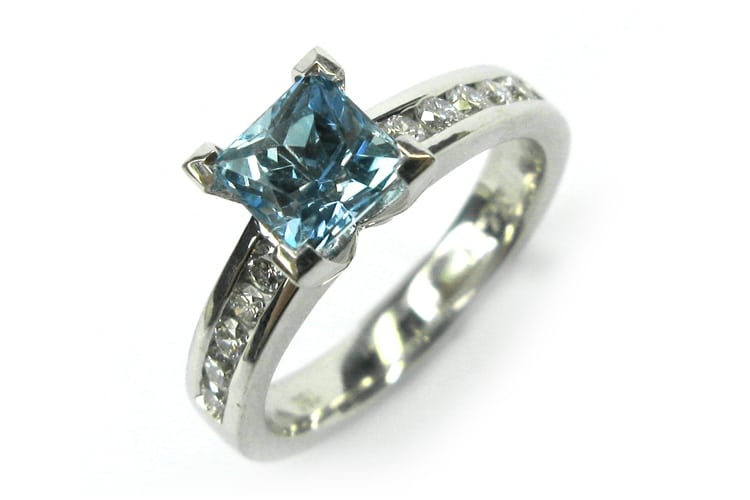 Aquamarine four claw set ring with channel set diamonds