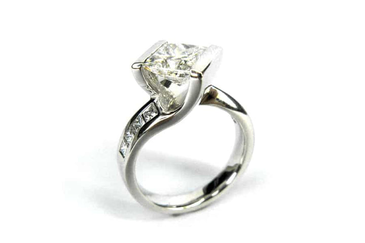 Princess cut diamond ring set on the diagonal with a twisted band and matching wedding band