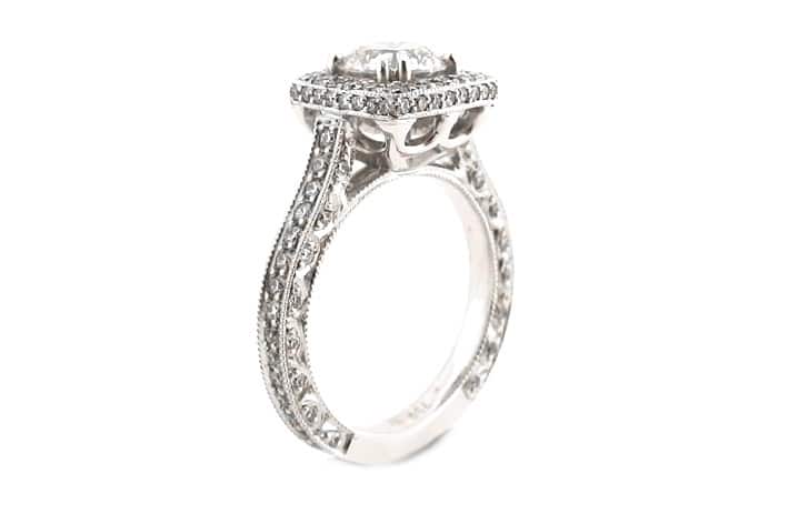 Round brilliant cut diamond ring set with double claws and a halo of diamonds