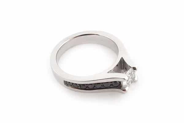 Round brilliant cut diamond ring with bead set black diamonds