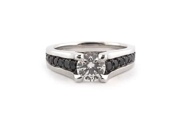 Round brilliant cut diamond ring with bead set black diamonds