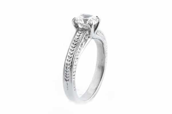 Round brilliant cut diamond ring with engraving on the band
