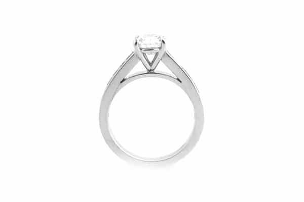 Round brilliant cut four claw set ring with graduated princess cut diamonds