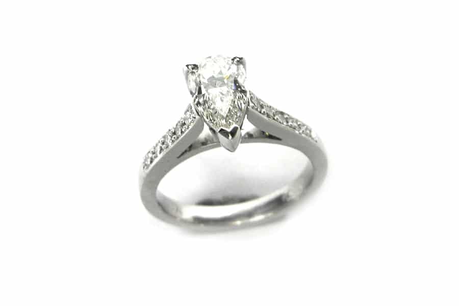 Pear shape diamond ring with bead set diamonds on the band