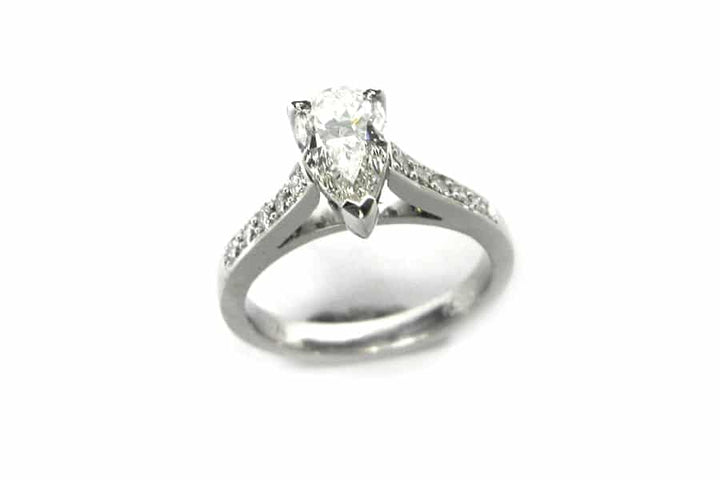 Pear shape diamond ring with bead set diamonds on the band