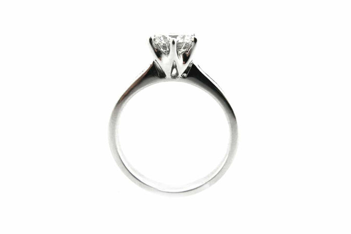 Six claw set round brilliant cut diamond ring with channel set diamonds