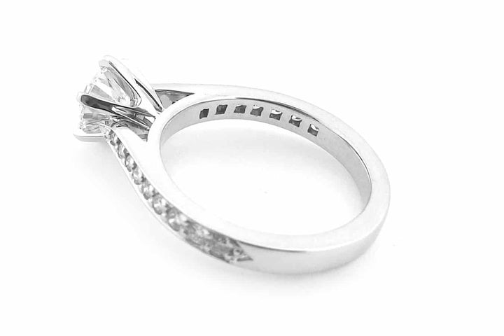 Six claw set round brilliant cut ring with bead set diamonds