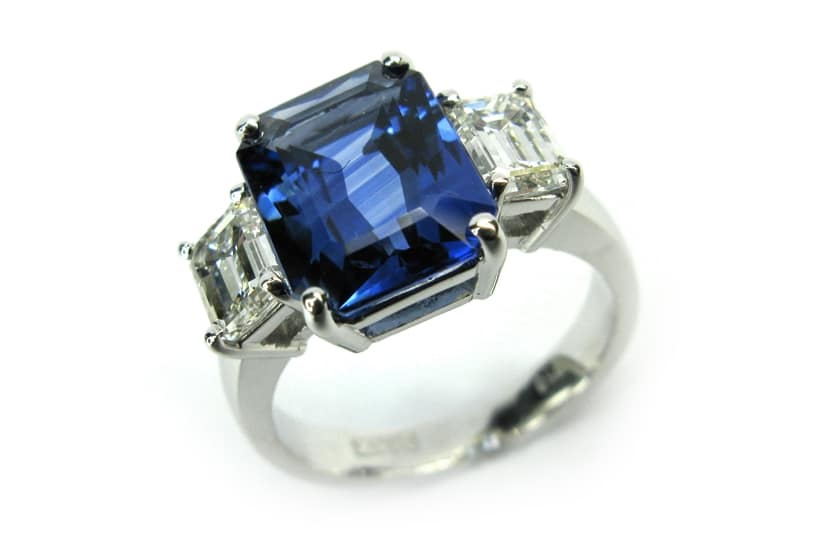 Three stone emerald cut sapphire and diamond ring
