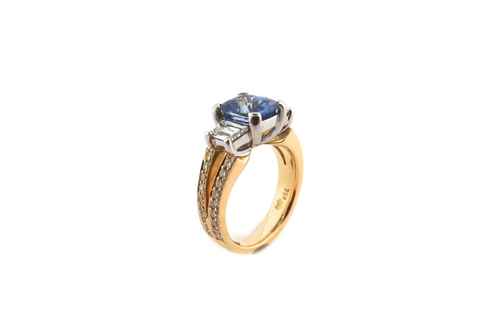 Three stone ring with a cushion cut sapphire and a split band
